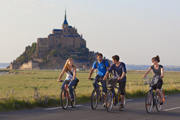 Fahrradfahrende Teenager vor dem Mont Saint-Michel
